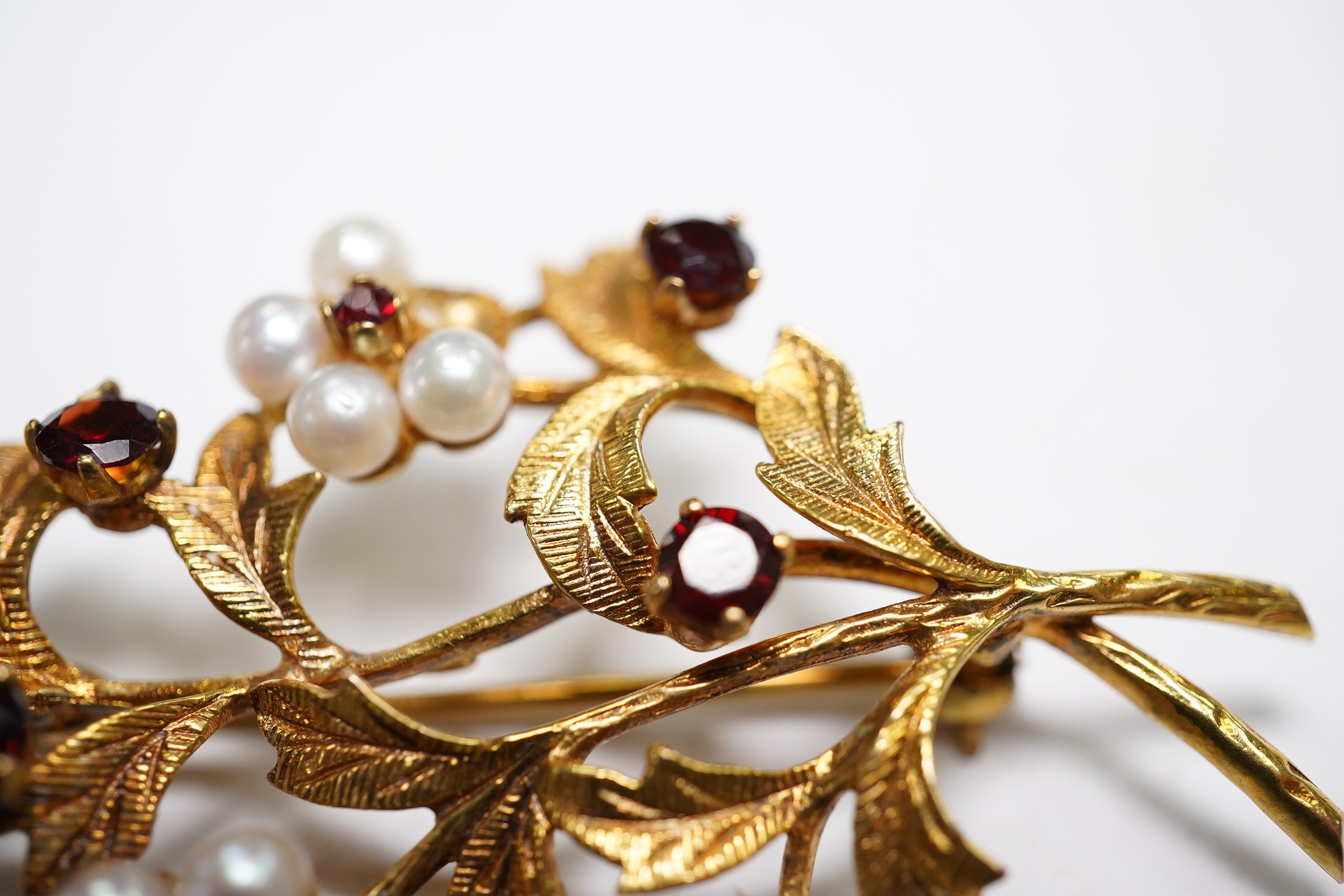 A 1960's 9ct gold, cultured pearl and garnet cluster set foliate spray brooch, 52mm (three pearls missing), gross weight 9.3 grams. Condition - poor